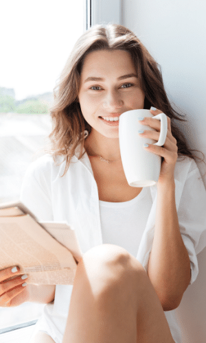 eine Frau, die etwas aus einer Tasse trinkt